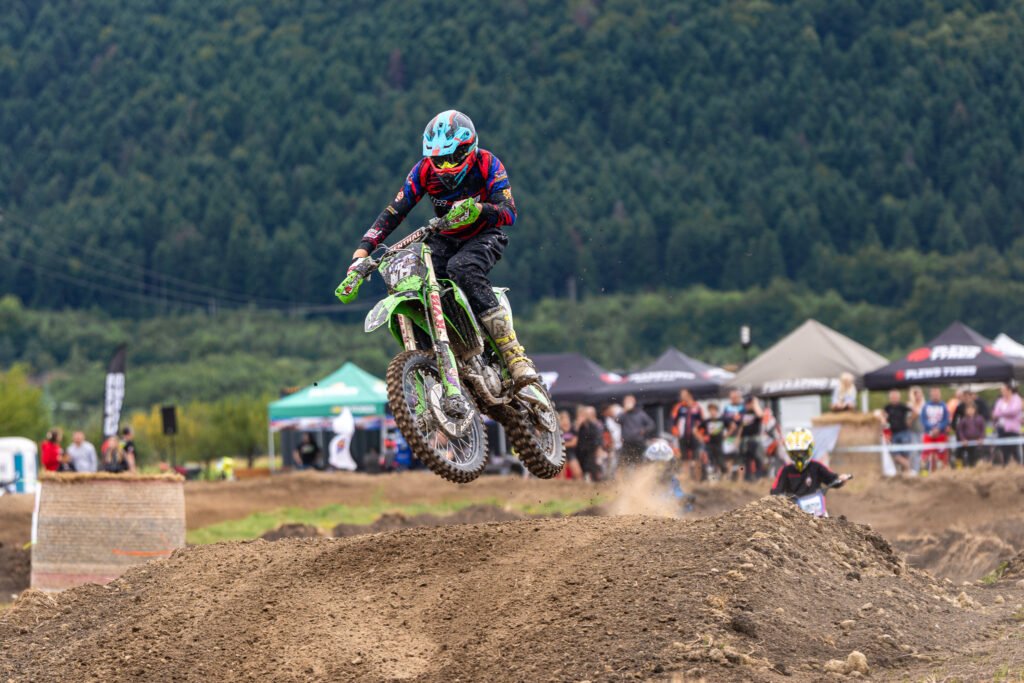 Motocross vozač u skoku iznad zemljane staze