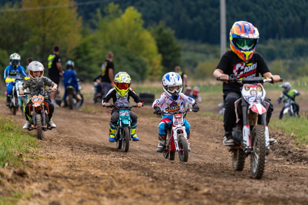Djeca voze male motocikle na zemljanoj stazi